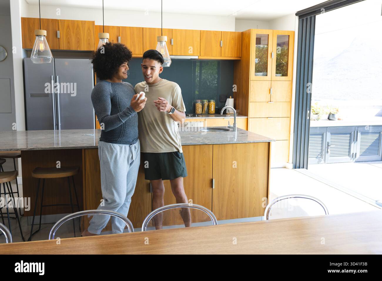 Mostra diversi amici maschi di mela bianca in piedi a casa, con smartwatch Foto Stock