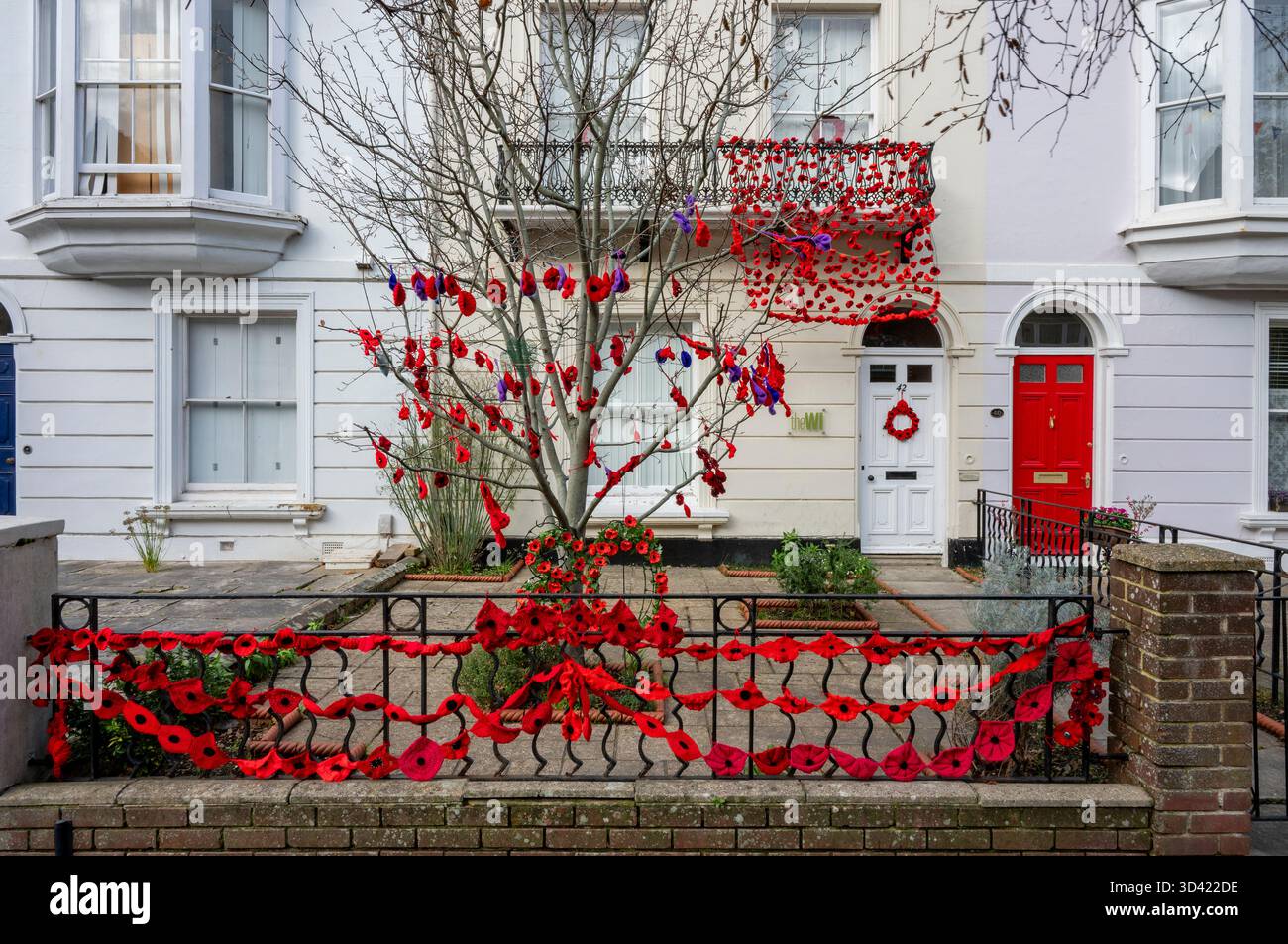 Grande casa d'epoca a Newport, sull'isola di wight, decorata con papaveri rossi luminosi per l'appello del papavero della Royal British legion la domenica del ricordo Foto Stock