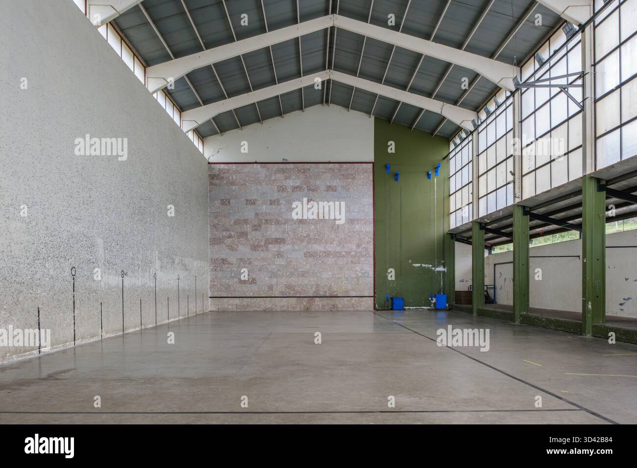 Interni vuoti della corte basca di Pelota, frontone con soffitto a volta alto, struttura industriale in metallo, pareti intemprate, impianto sportivo tradizionale Foto Stock