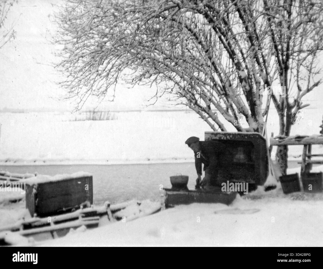 Un uomo risciacqua il cibo in un fosso durante una scena invernale vicino ad Amsterdam. L'atto è stato notato dagli ispettori sanitari nel 1919 durante la crisi del tifo. Foto Stock