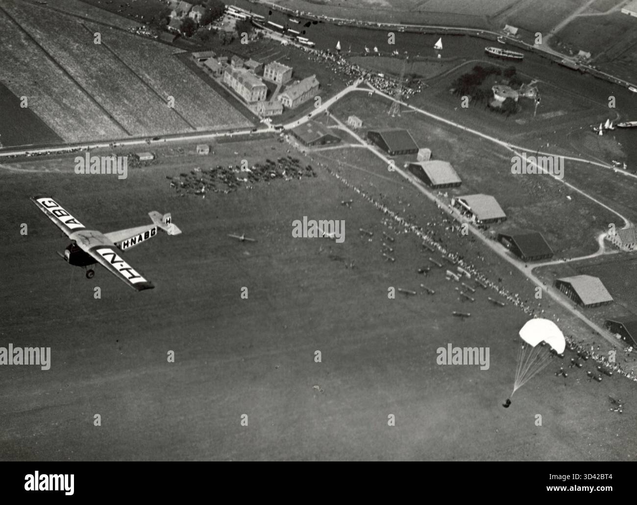 In occasione della giornata nazionale dell'aviazione del 1923 a Schiphol, nei Paesi Bassi, un paracadutista fa un salto con un "pop" per intrattenere la folla. Questo spettacolo ha aggiunto un aspetto emozionante all'evento dell'aviazione. Foto Stock