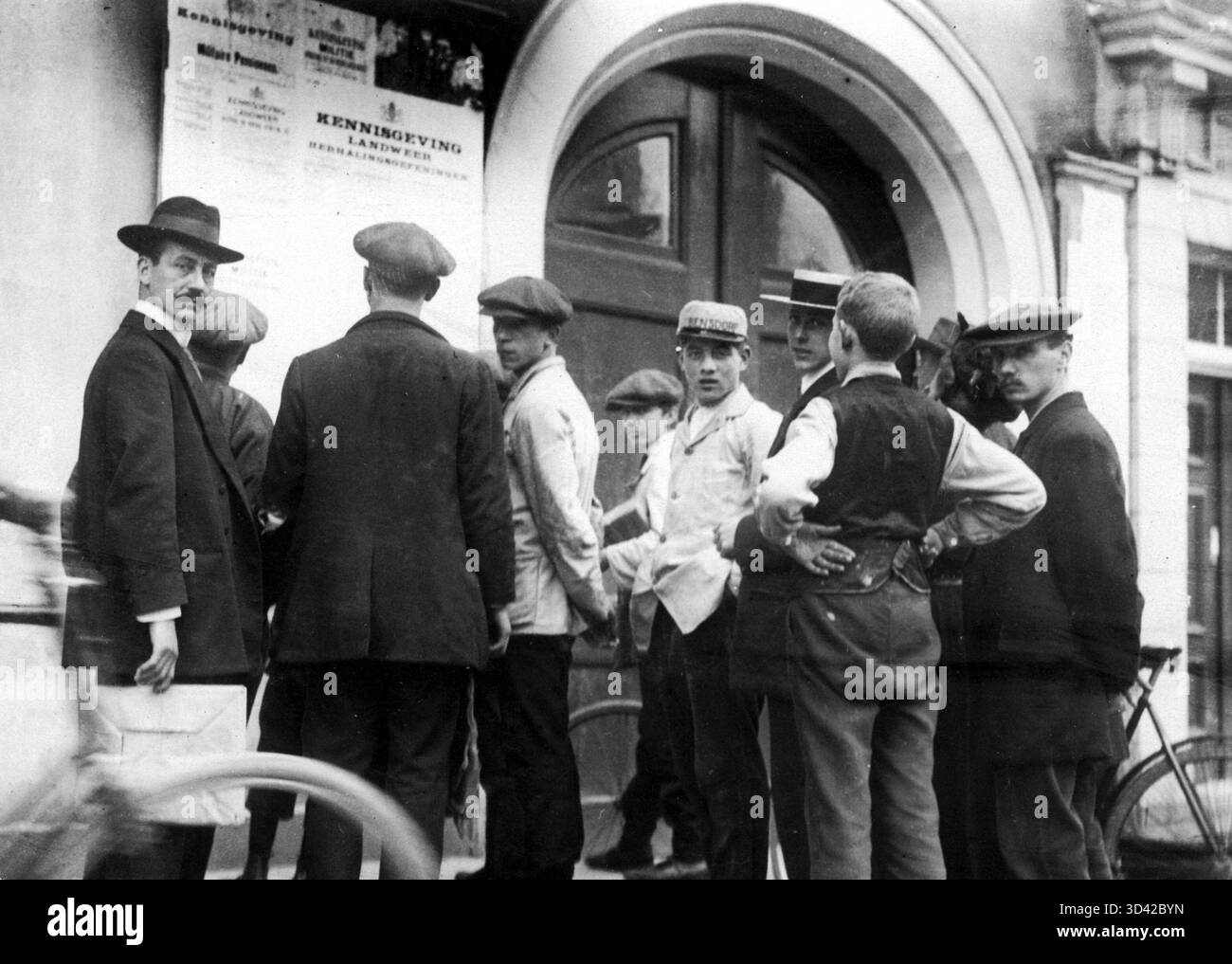 Questa fotografia del 1914 mostra un gruppo di uomini che leggono avvisi sulla mobilitazione durante la prima guerra mondiale. Rappresenta gli sforzi di mobilitazione che hanno avuto luogo nei Paesi Bassi per prepararsi a un possibile coinvolgimento militare. Foto Stock
