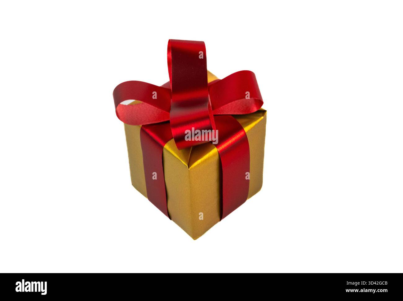 Confezione regalo per le feste, confezionata in carta oro con fiocco e nastro rosso, perfetta per Natale, compleanni e festeggiamenti. Foto Stock