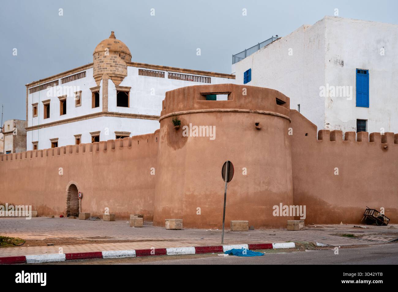 Piccola torre angolare delle mura rosa della città di Essaouira, Marocco, catturata in una mattinata tranquilla. La luce soffusa mette in risalto i toni pastello delle pareti in pietra Foto Stock