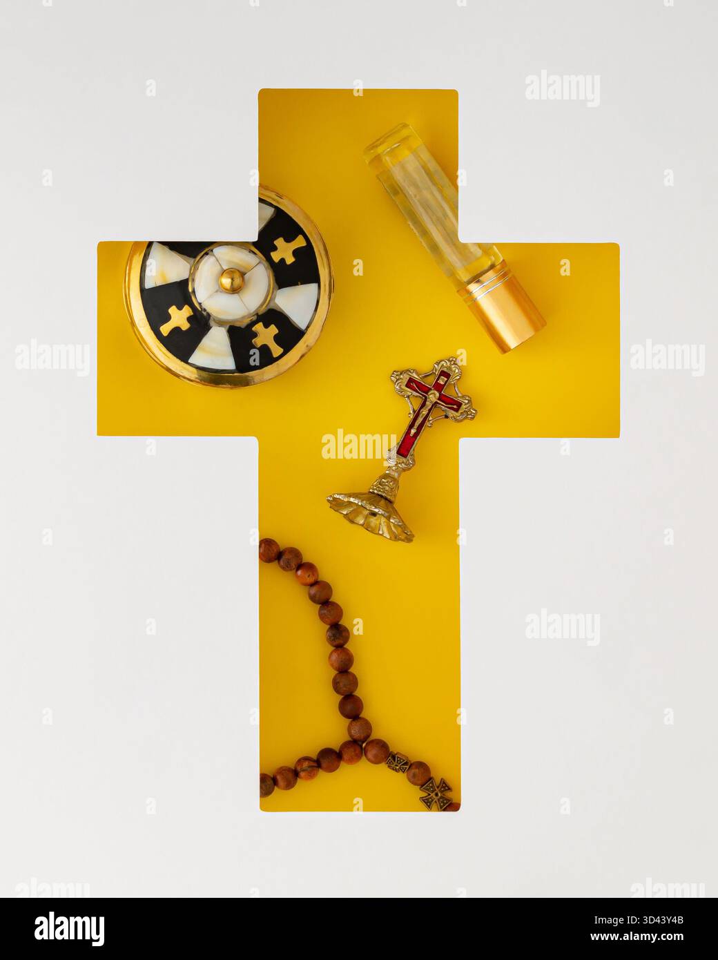 Oggetti cristiani ortodossi visibili attraverso una fessura a forma di croce su sfondo giallo. Concetto cristiano ortodosso minimale. Appartamento religioso. Foto Stock