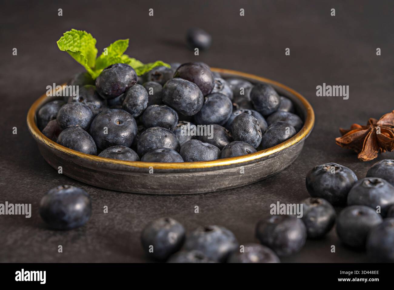 Il contrasto tra il nero assoluto dello sfondo e le tonalità bluastre dei mirtilli crea un'immagine quasi astratta di grande effetto visivo Foto Stock