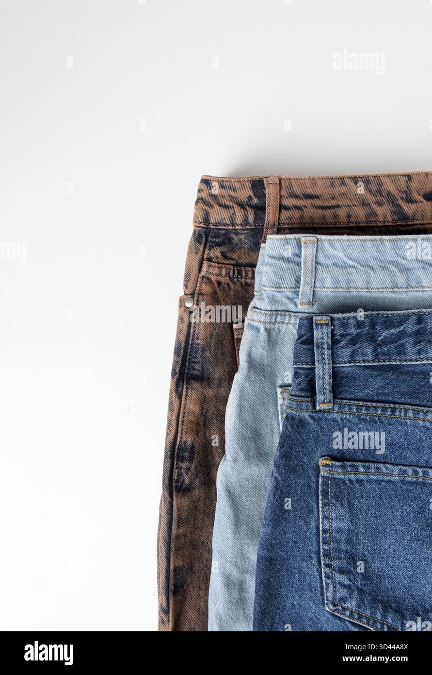Blu, azzurro, jeans marroni su sfondo bianco, piatto, spazio copia Foto Stock