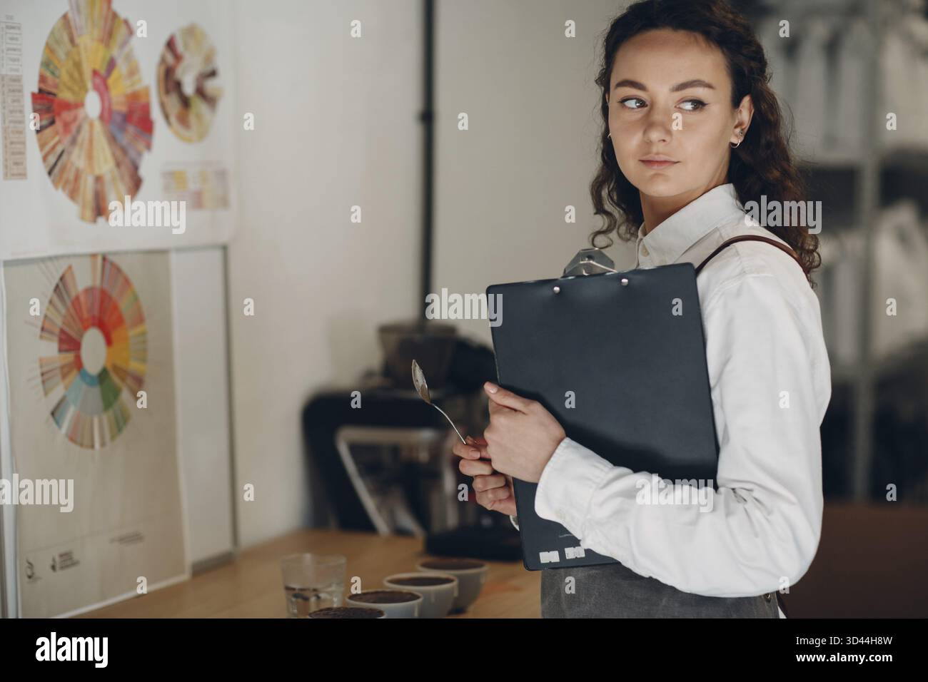 Assaggiatore di tazze donna con cucchiaio in mano prova di qualità del caffè Degustation. Coppetta di caffè Foto Stock