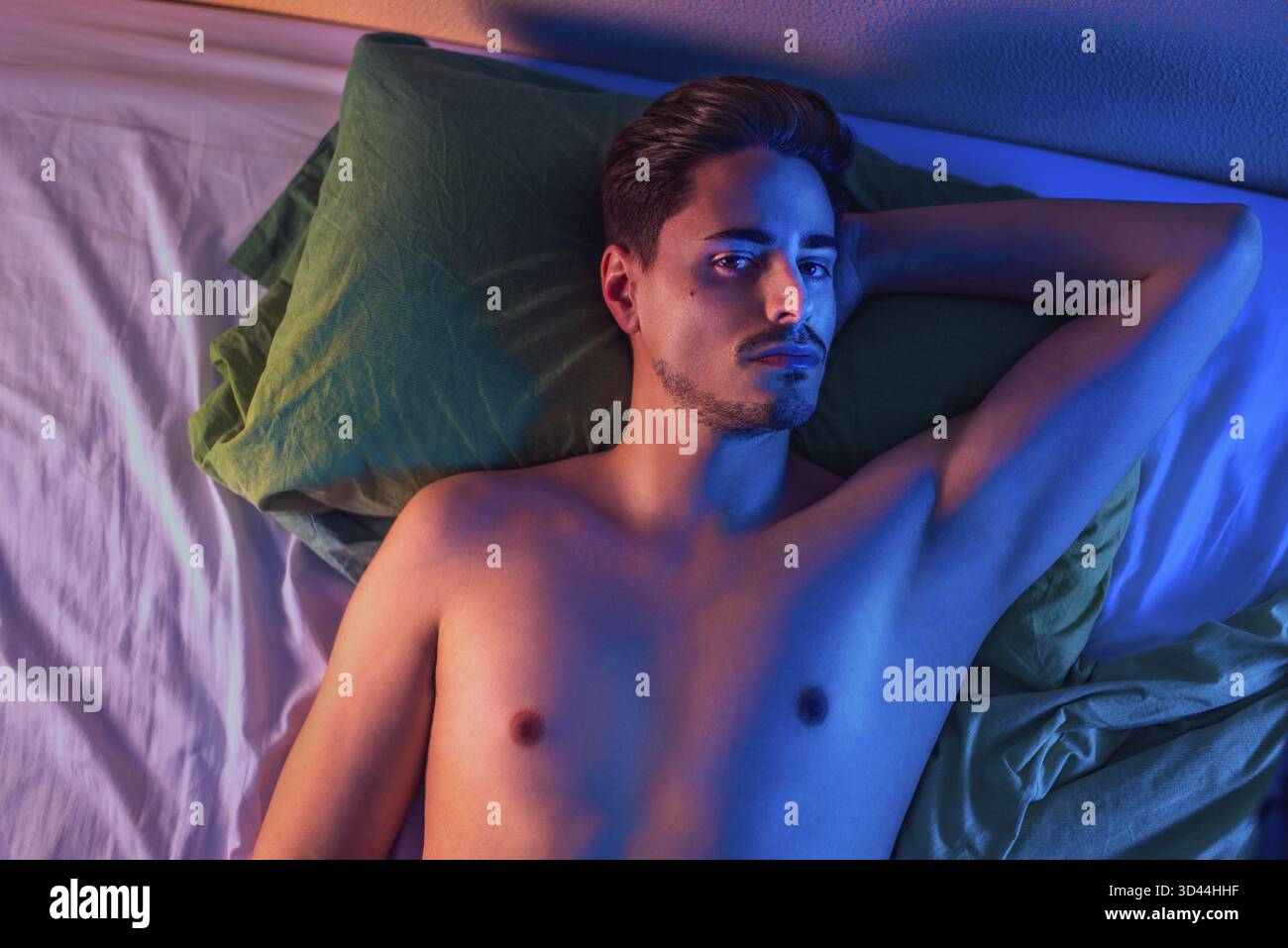 Ritratto di un giovane su un letto dall'alto Foto Stock