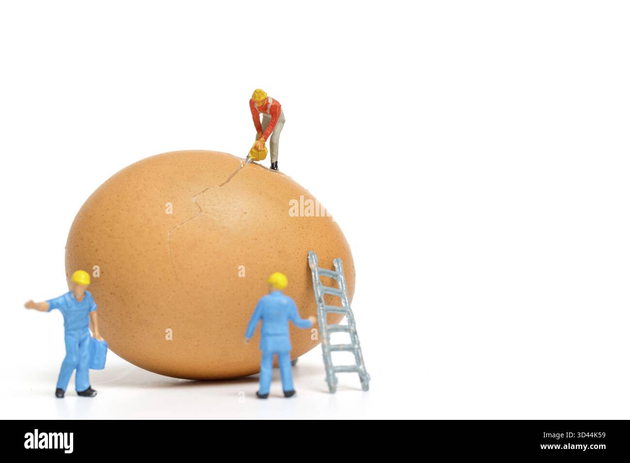 La gente in miniatura lavora alle uova di Pasqua per il giorno di Pasqua su bianco sfondo Foto Stock