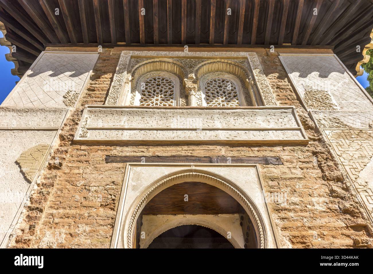 Moresco arco islamico al di sopra di una porta di legno in Granada, Spagna, Europa in una luminosa giornata di sole Foto Stock