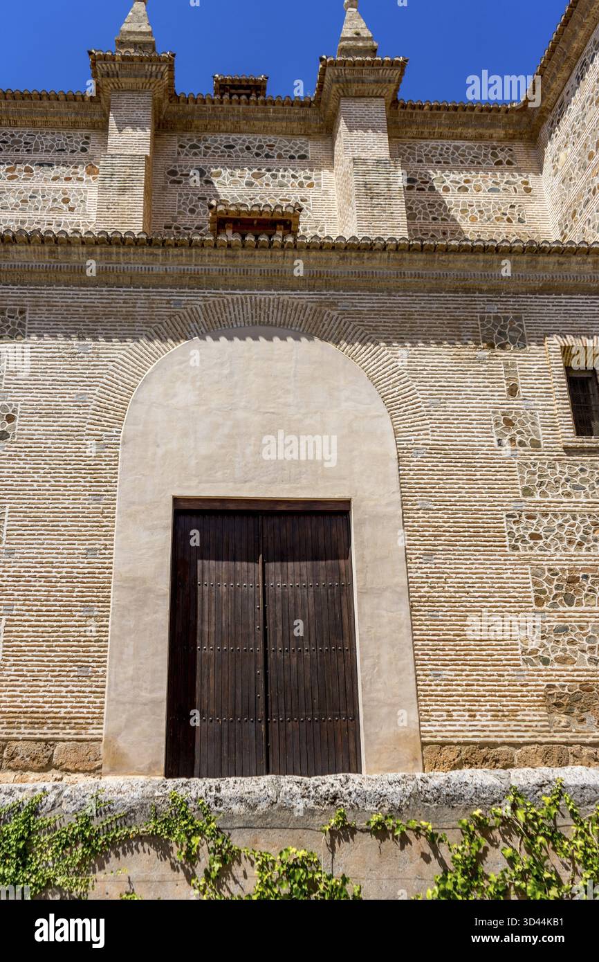Moresco arco islamico al di sopra di una porta di legno in Granada, Spagna, Europa in una luminosa giornata di sole Foto Stock