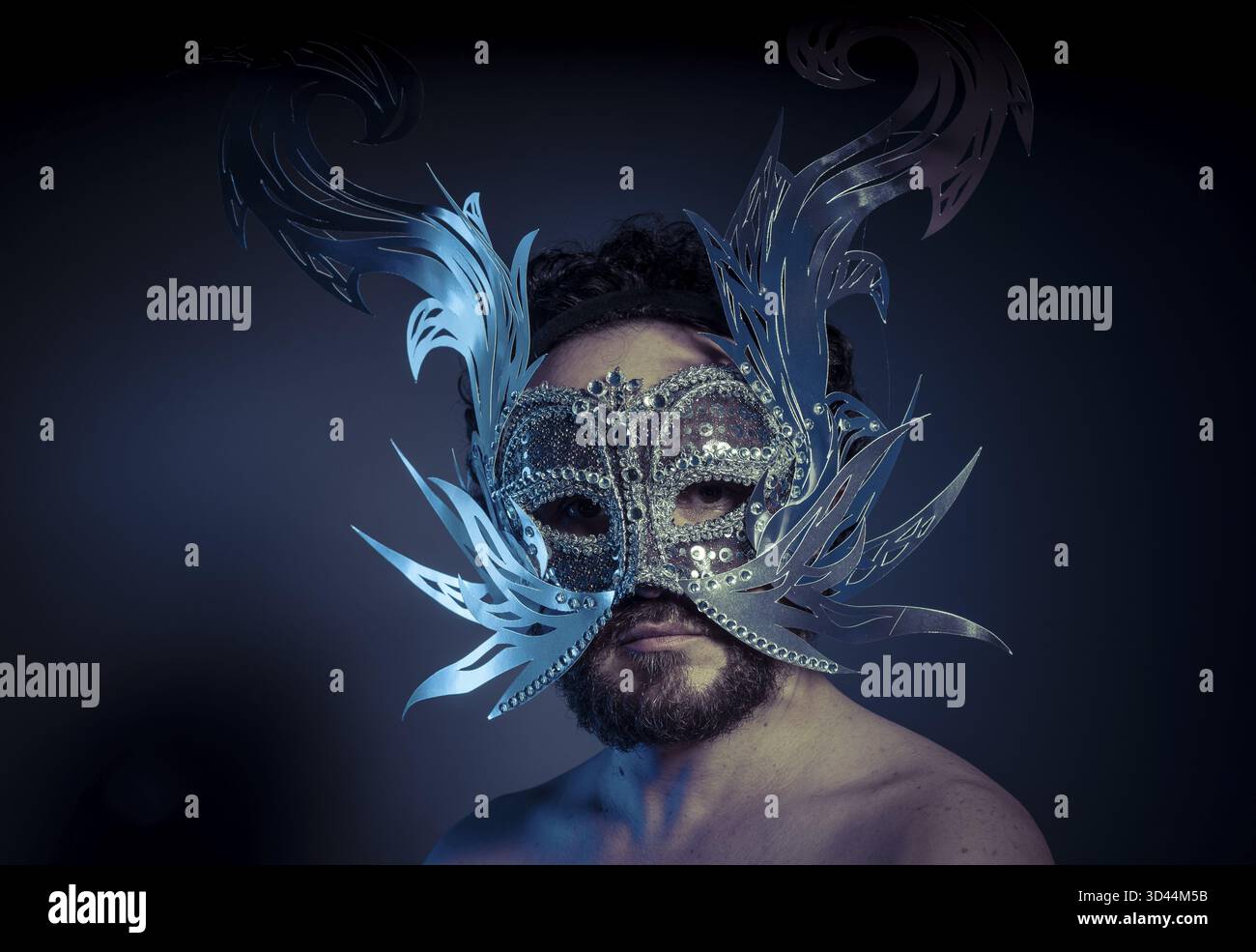 Uomo barbuto con maschera d'argento in stile veneziano. Mistero e rinascimento Foto Stock