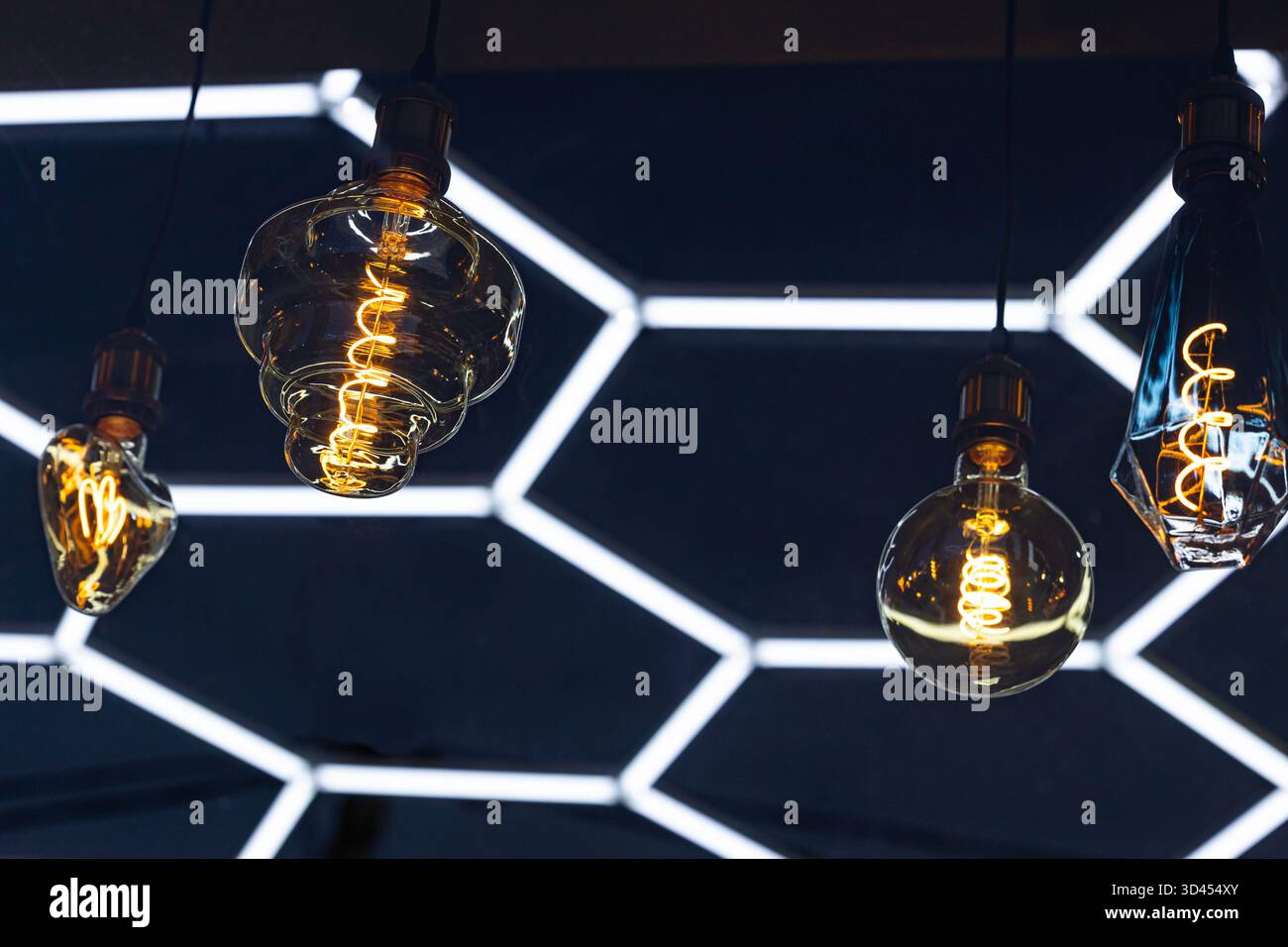 Una lampadina decorativa a incandescenza è appesa a un soffitto scuro. Foto Stock