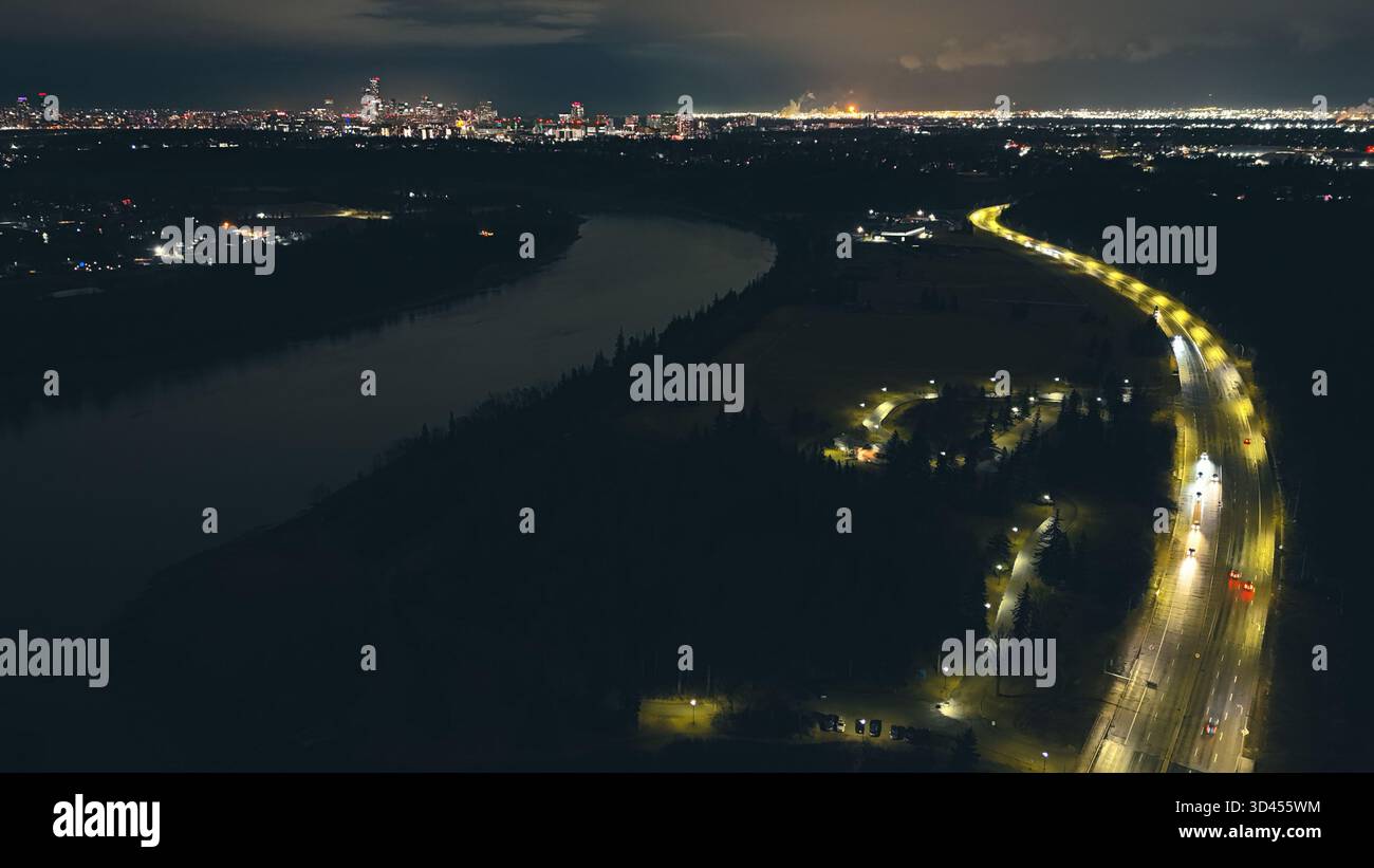 Vista aerea notturna del fiume della città e delle strade circostanti illuminate da lampioni Foto Stock