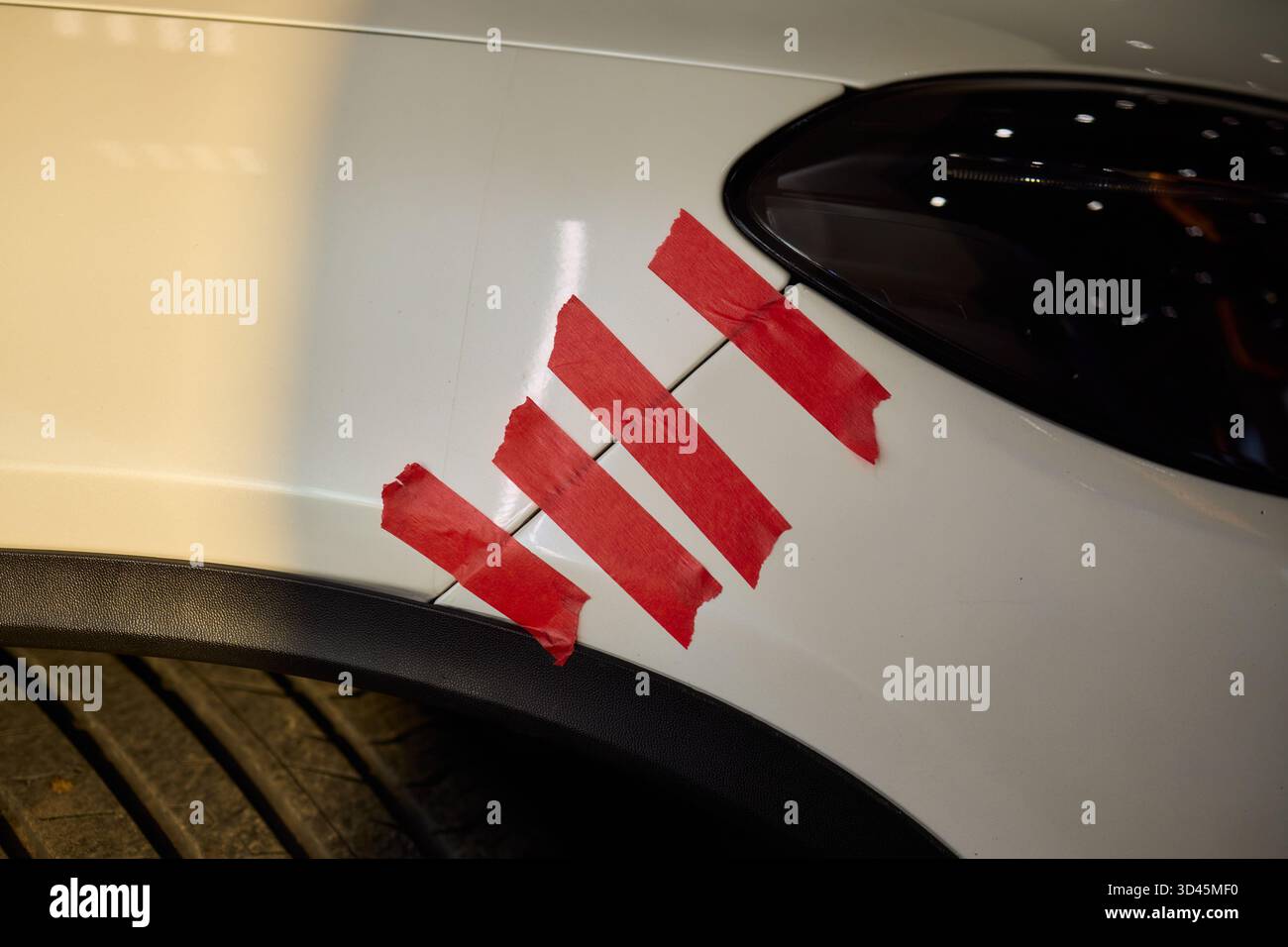 Analisi dei danni del veicolo, la fotografia si concentra sul paraurti dell'auto con segni di usura visibili, una vista approfondita che evidenzia le condizioni del pannello del veicolo in Foto Stock