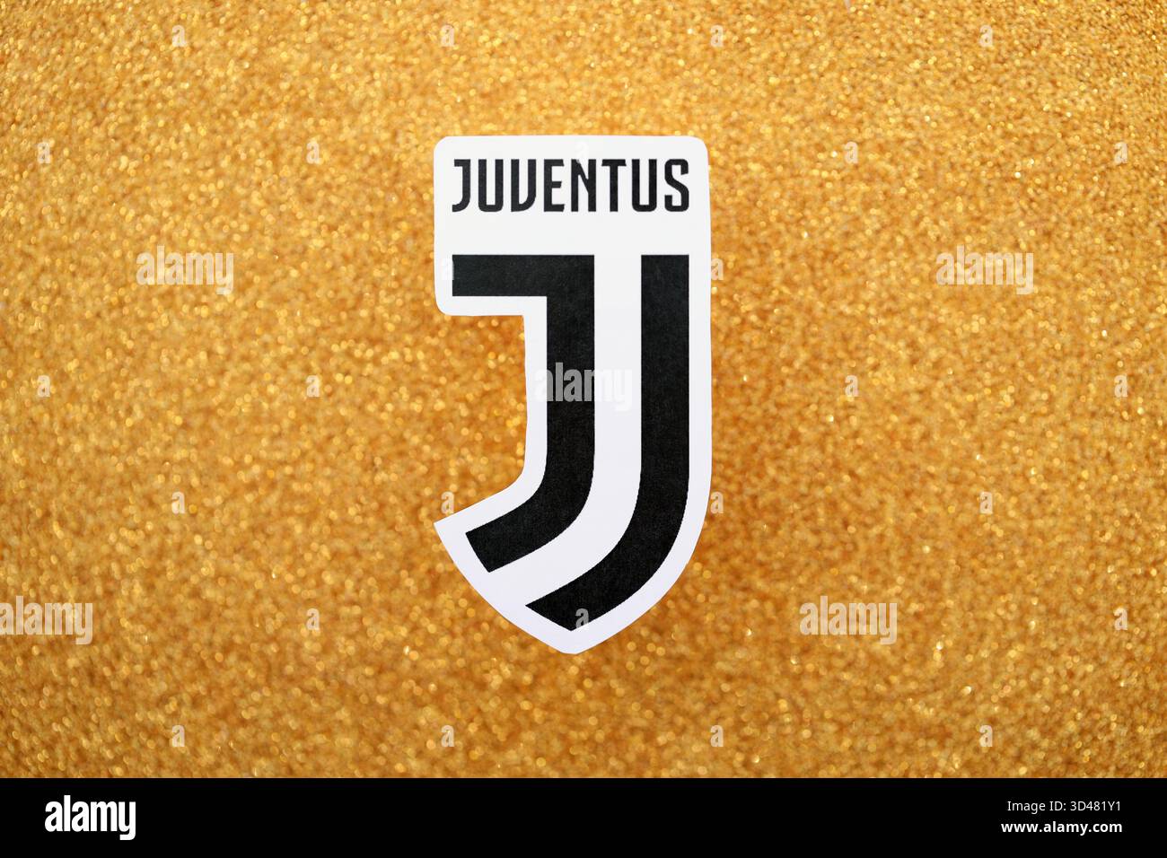 KIEV, UCRAINA - 23 FEBBRAIO 2025 il distintivo della squadra di calcio della Juventus FC si trova su uno sfondo giallo dorato glitter Foto Stock