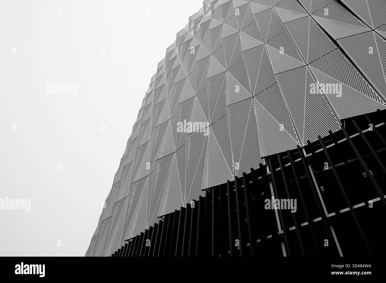 Vista astratta ad angolo basso di una facciata in metallo perforato con pannelli triangolari e pinne verticali, fotografata a Helsinki, Finlandia, in una giornata ricoperta. Foto Stock