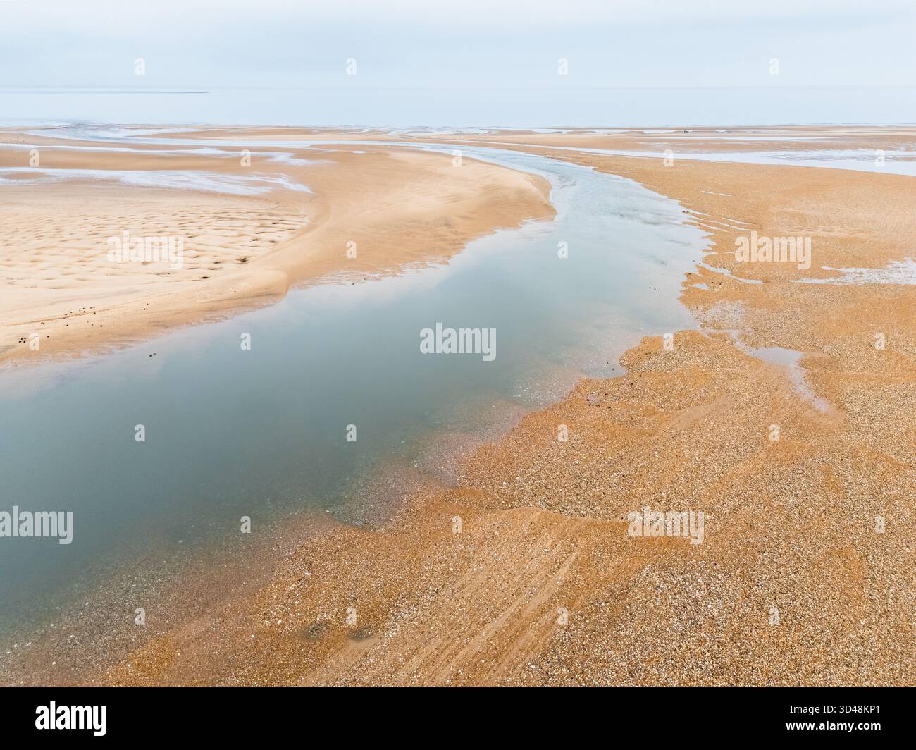 Una vista aerea di un grande canale d'acqua sulla spiaggia durante la bassa marea a Burnham Overy Staithe sulla costa nord del Norfolk. Foto Stock