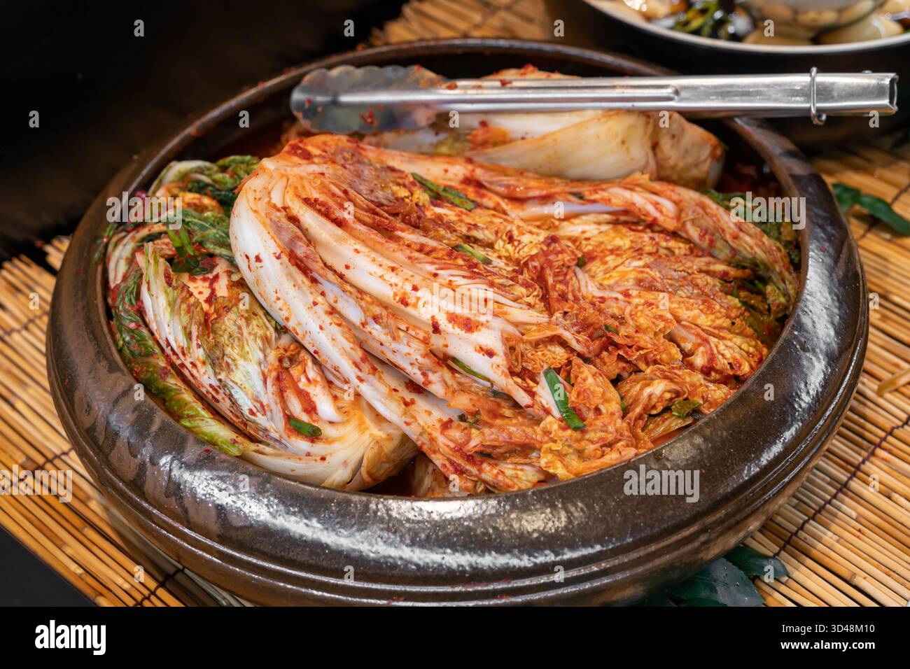 Tradizionale kimchi di cavolo coreano Napa fatto con scaglie di peperoncino, aglio, zenzero e salsa di pesce, fermentato per sviluppare una ricca speziata. Foto Stock