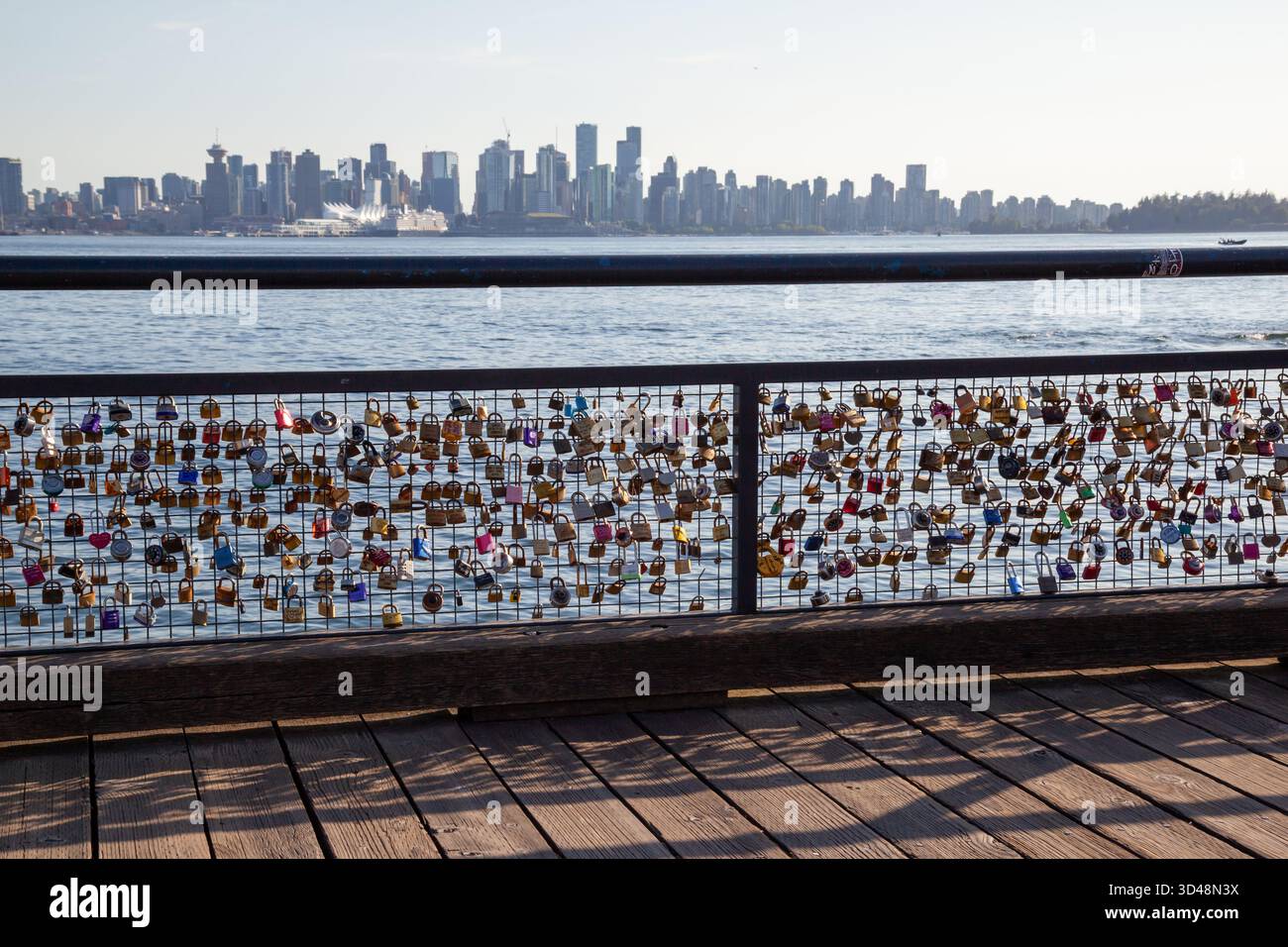 Love Locks chiuso sulla ringhiera con sfondo dello skyline di Vancouver al Lonsdale Quay Market a North Vancouver, British Columbia, Canada. Foto Stock