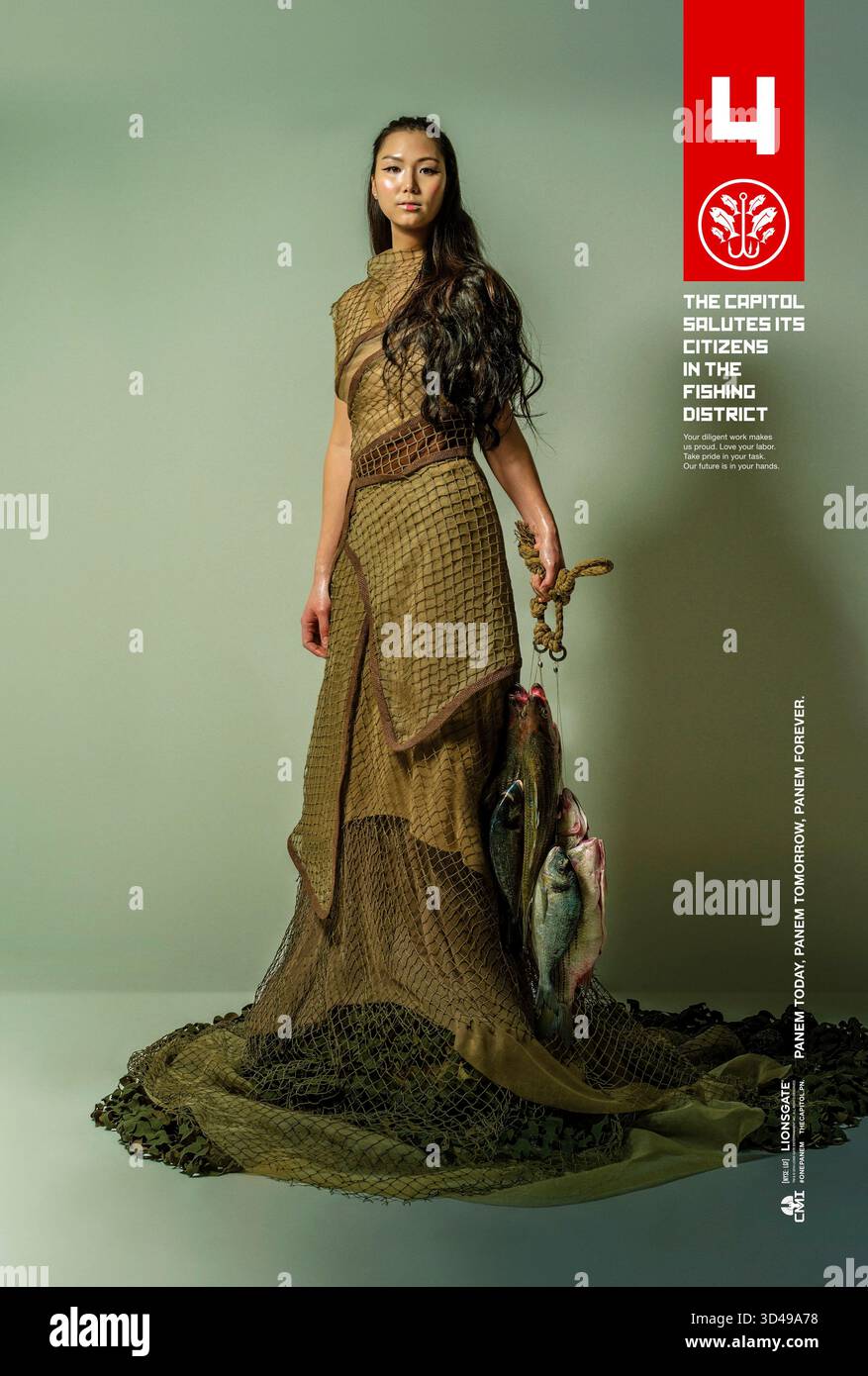 The Hunger Games: Mockingjay - Part 1 (2014) diretto da Francis Lawrence e interpretato da Jada Taylor nel ruolo di Naida Dolan. Figlia orgogliosa di un pescatore di acque profonde e di un tuffatore di perle di sesta generazione, Naida Dolan cancella la sua eredità mentre tiene orgogliosamente il pescato del giorno. USA Panem District propaganda promozionale poster SOLO PER USO EDITORIALE. Credito: BFA / Lionsgate Foto Stock