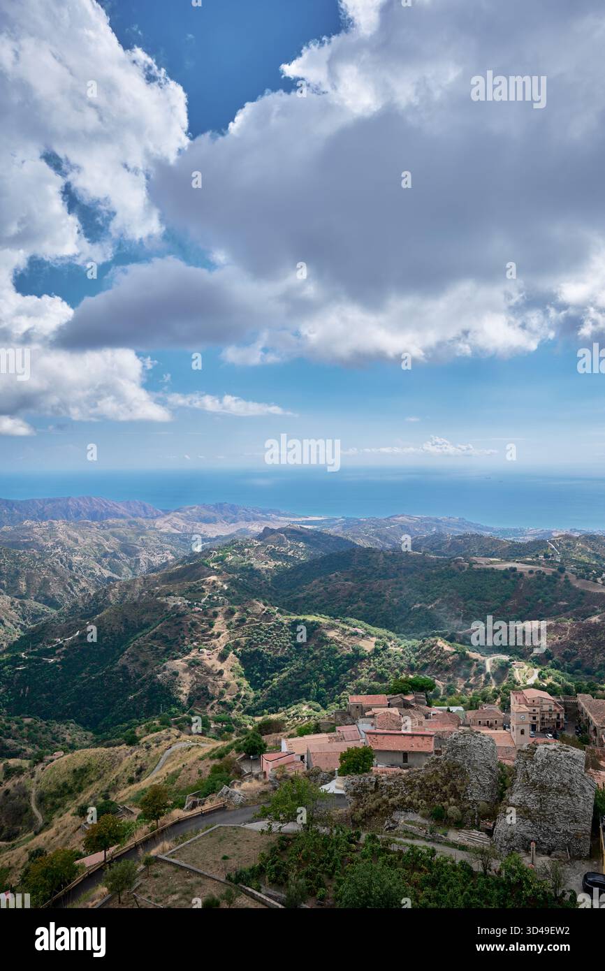 Vista panoramica di Aspromonte e del Mar Ionio vicino a Bova, Calabria, Italia meridionale con villaggio collinare e paesaggio mediterraneo sotto nuvole spettacolari Foto Stock