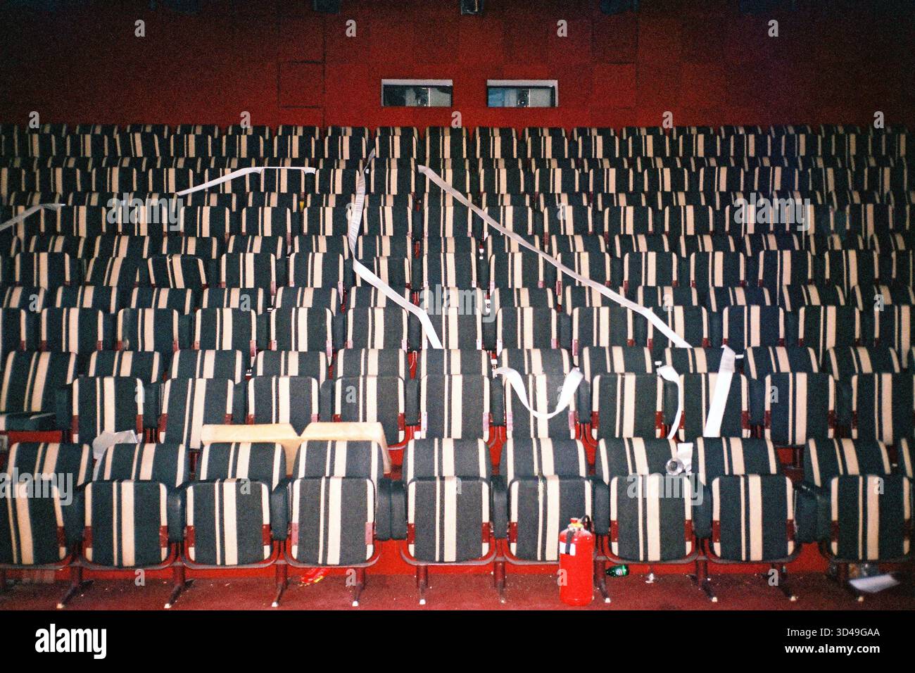 Sala cinematografica abbandonata al 26° piano della Genex Tower, foto flash analogica con posti vuoti, degrado urbano e atmosfera suggestiva. Foto Stock