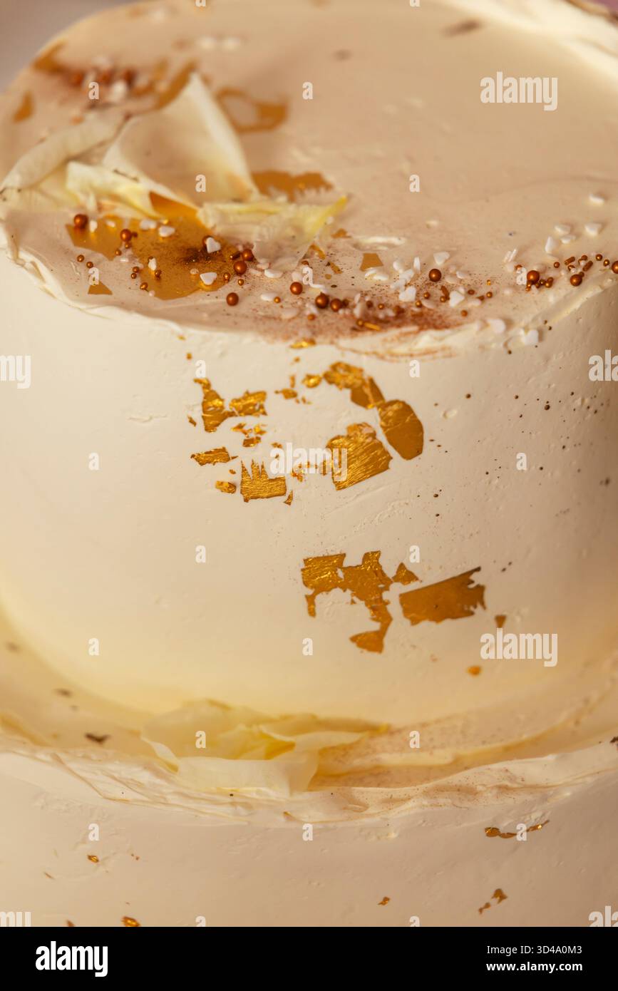 Ricca torta da dessert smerigliata decorata con foglie d'oro commestibili e piccole macchie Foto Stock