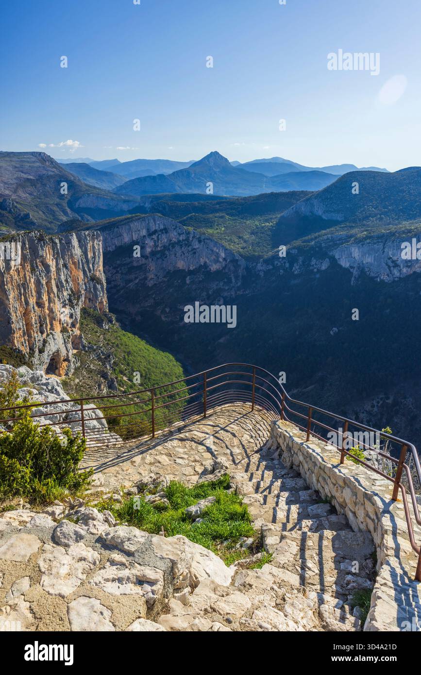 Punto panoramico che mostra le tortuose scale di pietra che scendono verso il profondo canyon e le montagne Foto Stock