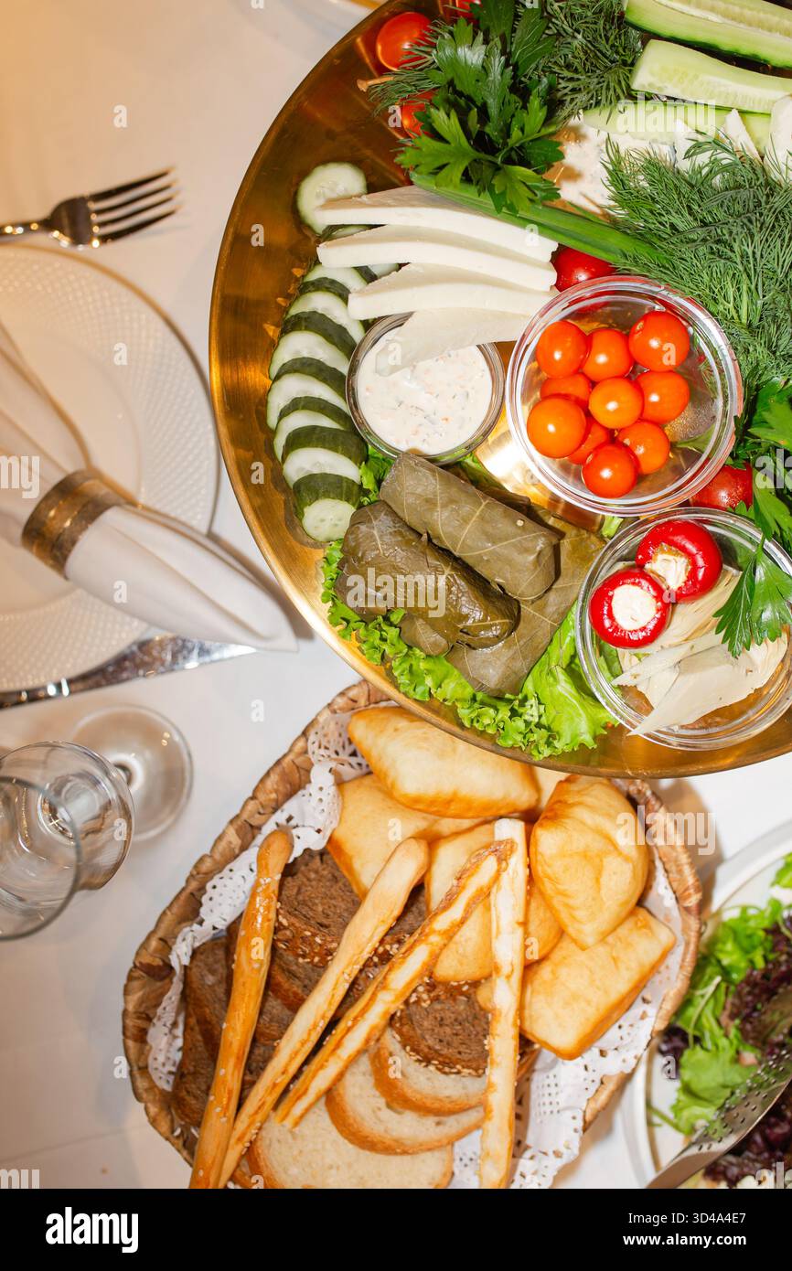 Mezze dallo stile ricco con verdure fresche e pane artigianale, ideali per catering di alto livello, cucina culturale o sofisticate immagini dell'ospitalità. Foto Stock