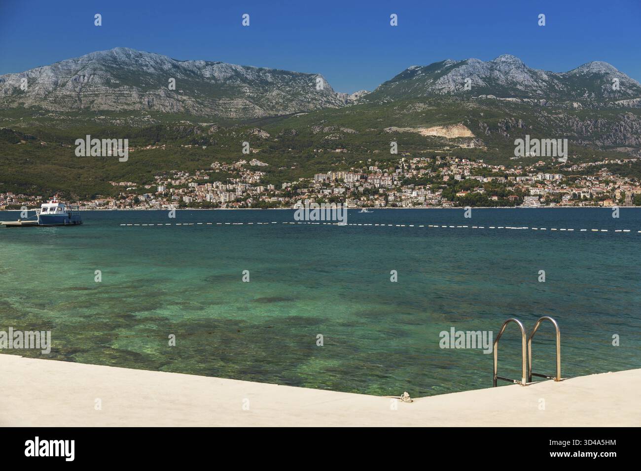 Vista pittoresca della cittadina di Herceg Novi nella baia di Cattaro, conosciuta anche come la Boka, in Montenegro. Vista dalla costa opposta Foto Stock