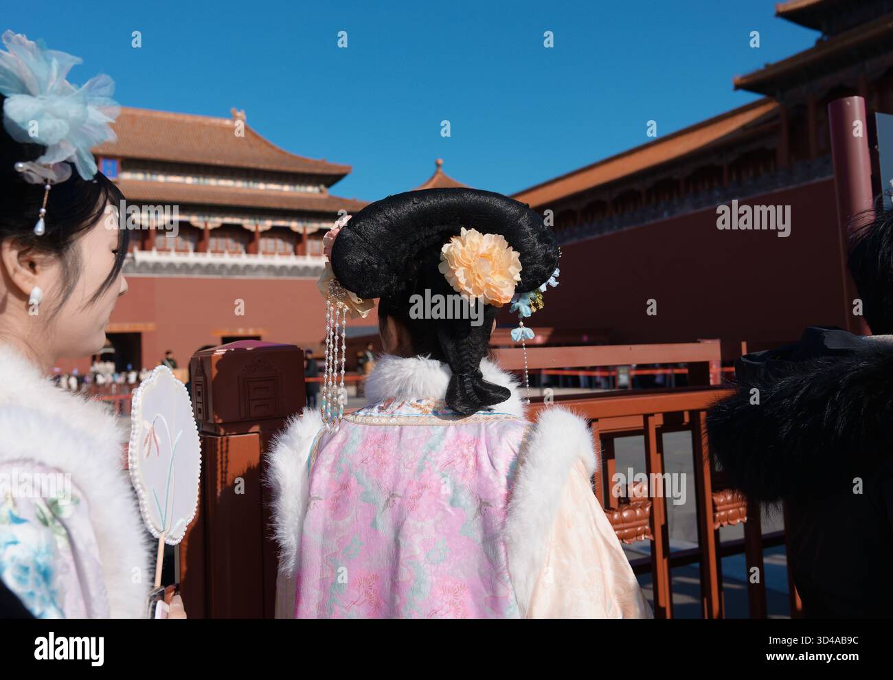 I visitatori vestiti con abiti cinesi tradizionali aspettano di entrare nella città Proibita di Pechino Foto Stock