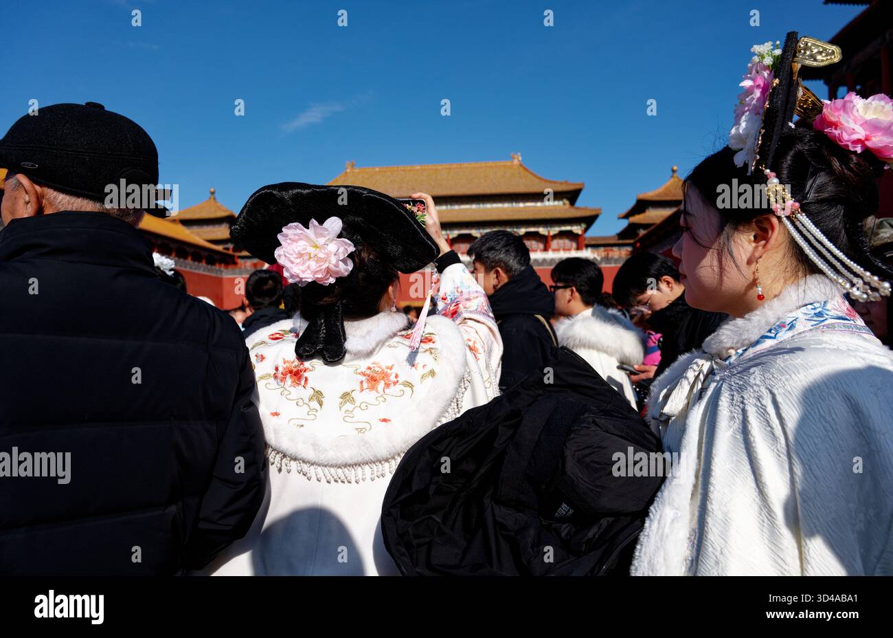 Folla nella città Proibita, visitatori in abiti tradizionali, scattando foto al cellulare delle porte del palazzo Foto Stock