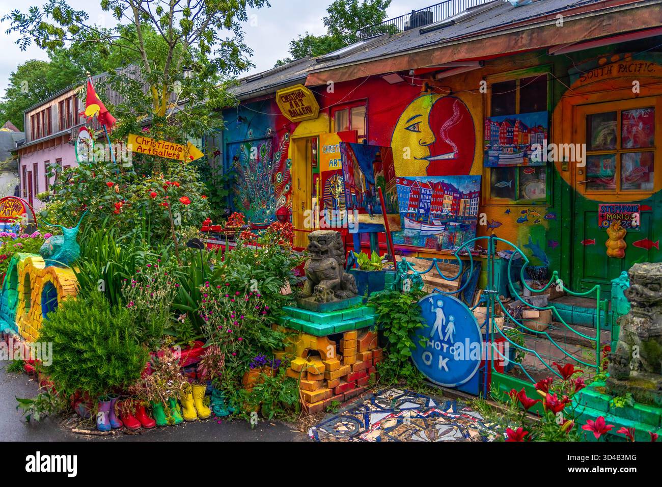 Facciata colorata dell'edificio nel quartiere di Christiania che presenta una galleria d'arte con murales, dipinti, piante lussureggianti e decorazioni uniche, che riflettono il c Foto Stock