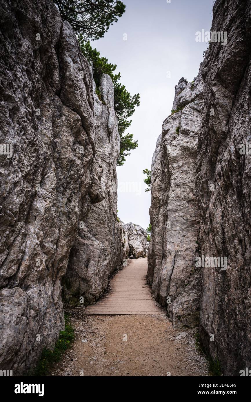 Passa attraverso le rocce su un sentiero escursionistico dalla cima del monte Kehlstein, sopra l'edificio del Nido dell'Aquila. Foto Stock