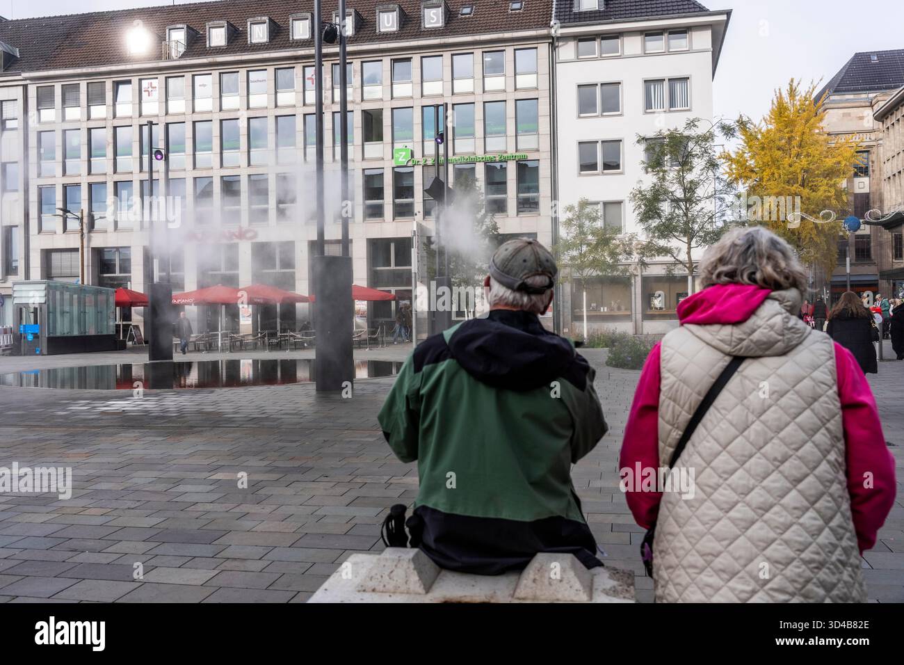 Impianto idrico digitale, installazione di acqua Blue Cloud su Husemannplatz nel centro di Bochum. La nebbia d'acqua viene spruzzata da quattro montanti metallici, che, in co Foto Stock