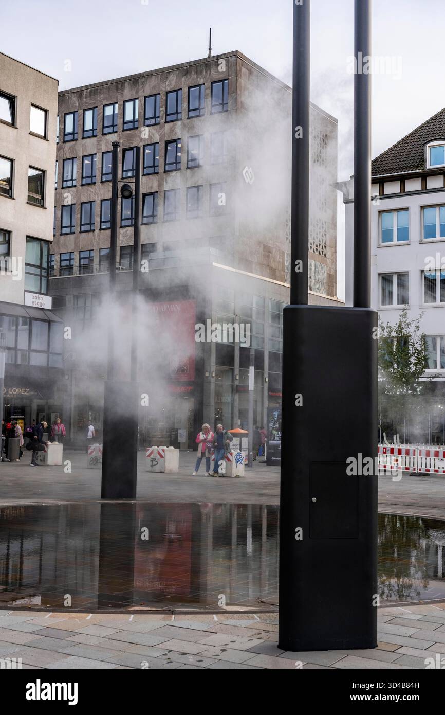 Impianto idrico digitale, installazione di acqua Blue Cloud su Husemannplatz nel centro di Bochum. La nebbia d'acqua viene spruzzata da quattro montanti metallici, che, in co Foto Stock