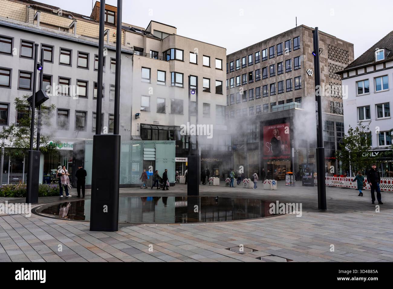 Impianto idrico digitale, installazione di acqua Blue Cloud su Husemannplatz nel centro di Bochum. La nebbia d'acqua viene spruzzata da quattro montanti metallici, che, in co Foto Stock