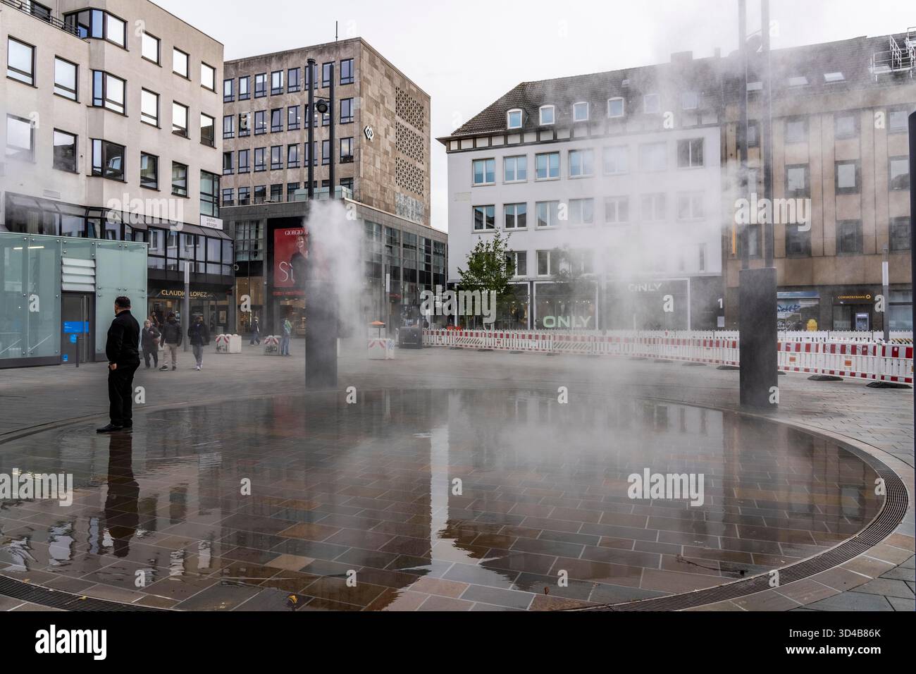 Impianto idrico digitale, installazione di acqua Blue Cloud su Husemannplatz nel centro di Bochum. La nebbia d'acqua viene spruzzata da quattro montanti metallici, che, in co Foto Stock