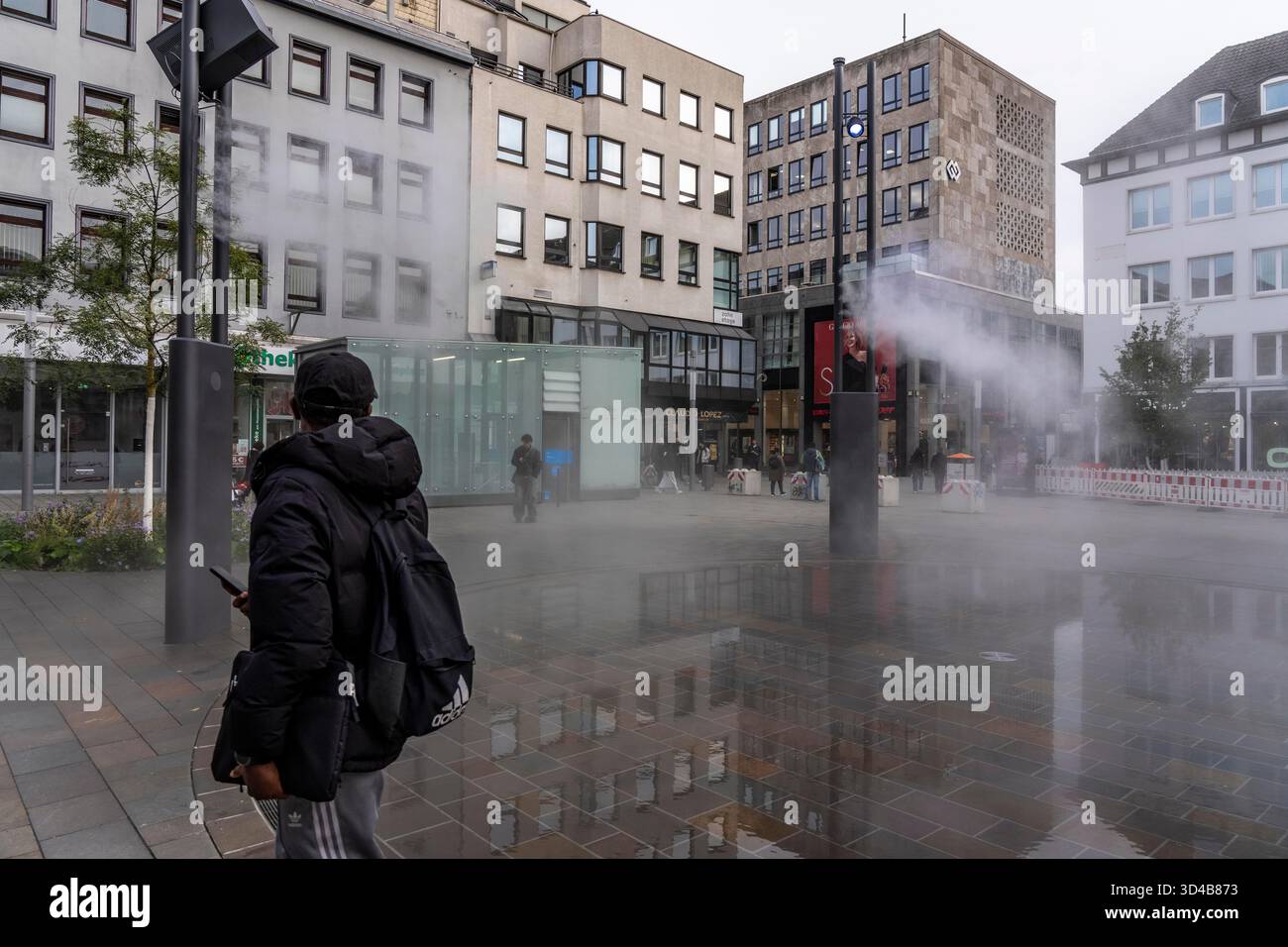 Impianto idrico digitale, installazione di acqua Blue Cloud su Husemannplatz nel centro di Bochum. La nebbia d'acqua viene spruzzata da quattro montanti metallici, che, in co Foto Stock