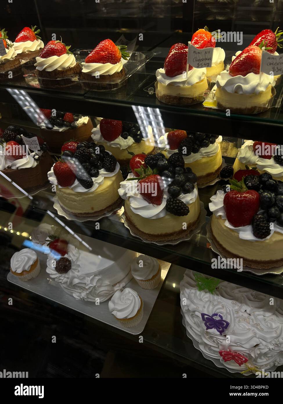 Pasticcini e torte di frutta assortiti in una vetrina da forno - Immagine stock catturata con smartphone
