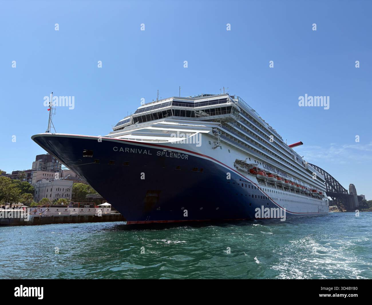 Nave da crociera Carnival Splendor ormeggiata o in barca a vela nel porto di Sydney in una giornata di sole con il Sydney Harbour Bridge visibile sullo sfondo. Foto Stock