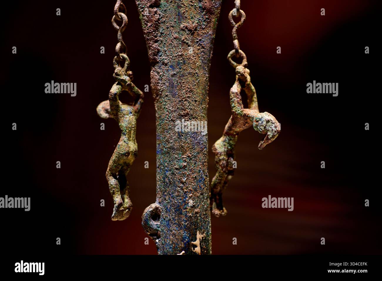 Primo piano dell'antica scultura in bronzo del Museo Nazionale della Cina, Pechino - persone appese per le braccia in catene su una lancia Foto Stock