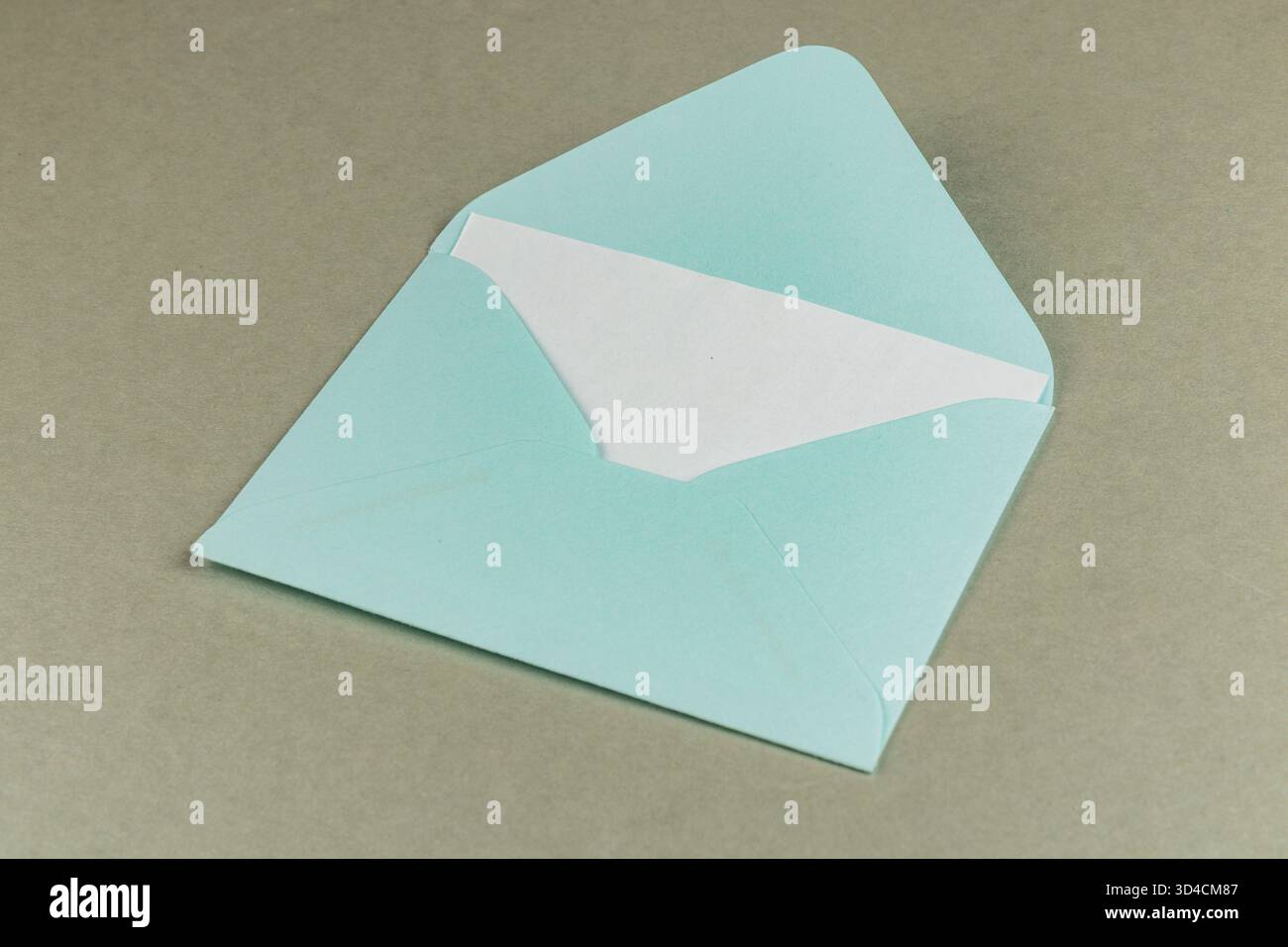 Una busta azzurra con rivestimento interno bianco si trova su uno sfondo semplice, pronta a contenere una lettera o un biglietto per la consegna. Foto Stock