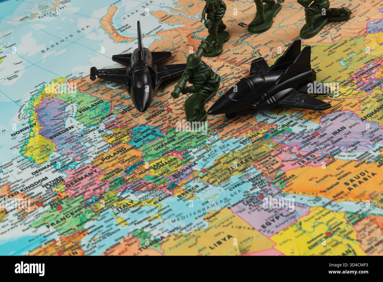 I soldati giocattolo di plastica e i getti da combattimento sono posizionati su una mappa luminosa del mondo. Sono visibili varie regioni d'Europa e Asia, che mostrano geografia e giochi Foto Stock