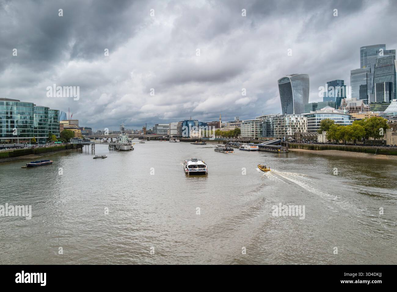 Varie barche navigano sullo storico fiume Tamigi con gli edifici iconici della City di Londra vicino all'Embankment di Londra nel Regno Unito. Foto Stock