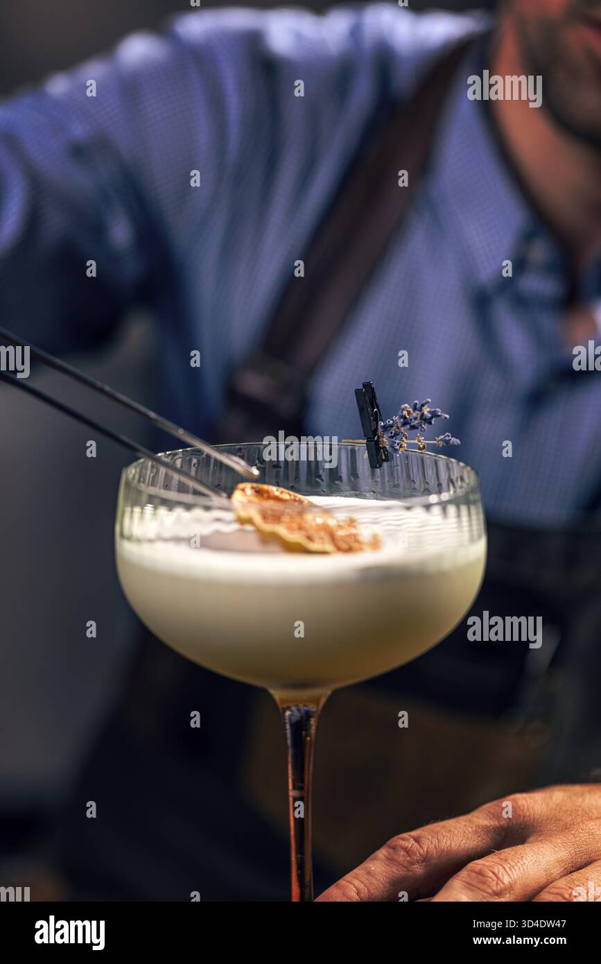 Cocktail da barman con arancia secca e lavanda Foto Stock