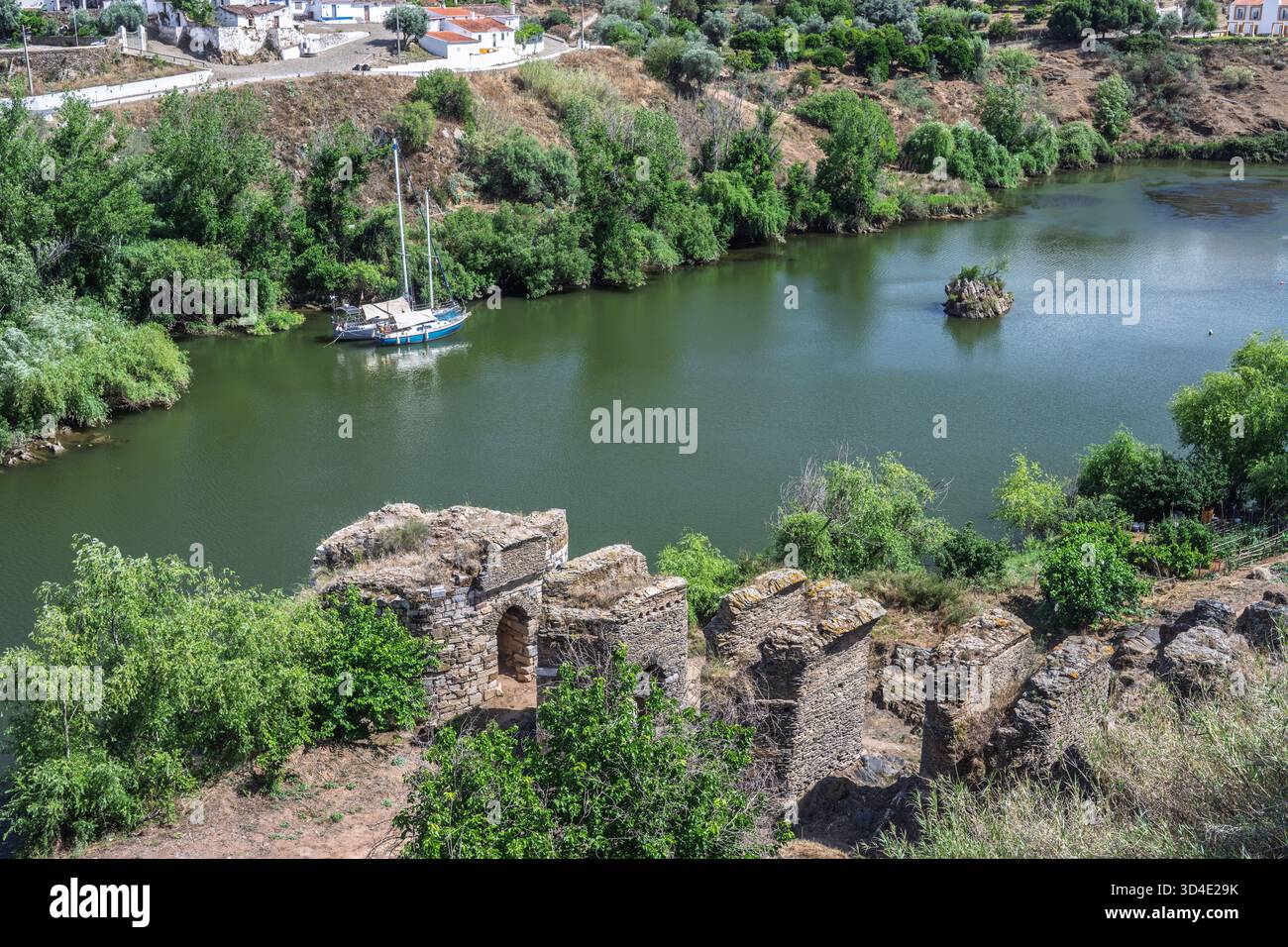 Il fiume Guadiana scorre lungo le antiche rovine di Torre do Rio a Mertola, mostrando la ricca storia della città e lo splendido paesaggio. Foto Stock