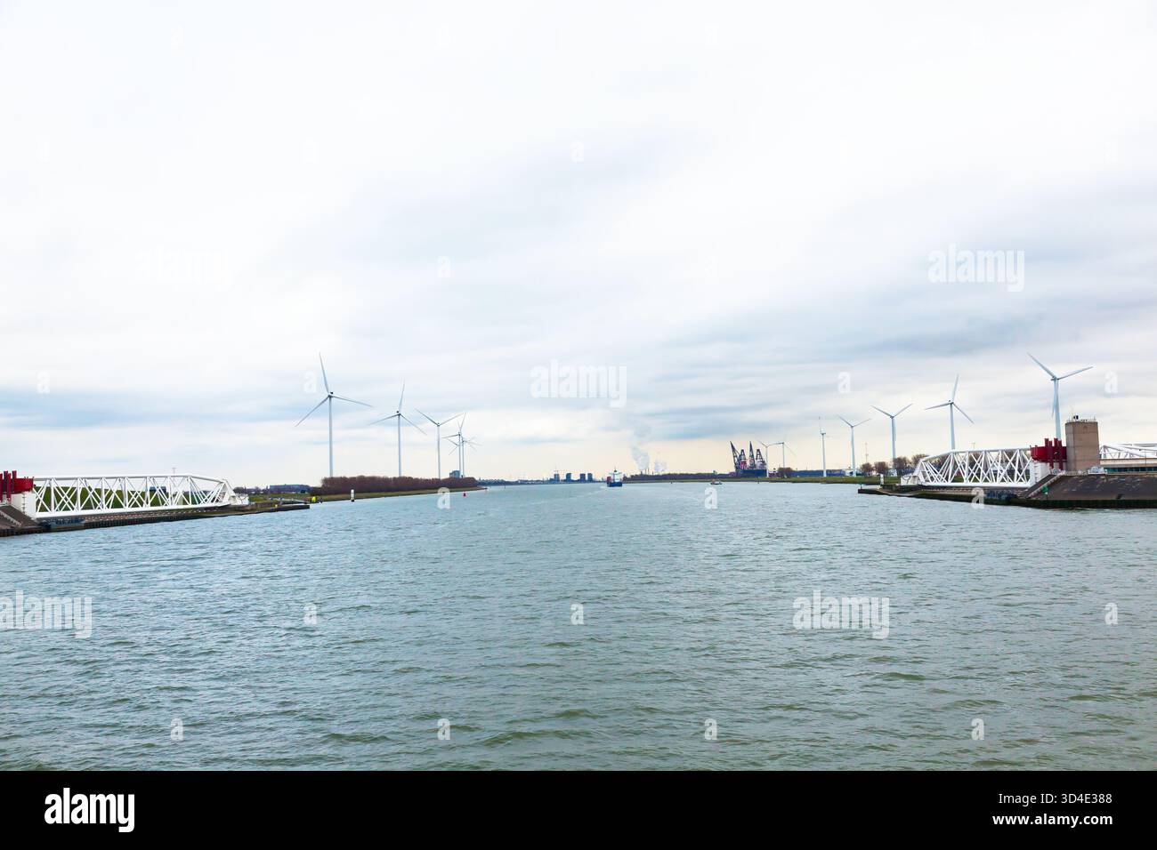 Un canale nei sobborghi di Rotterdam con un ponte scorrevole e generatori eolici. Foto Stock